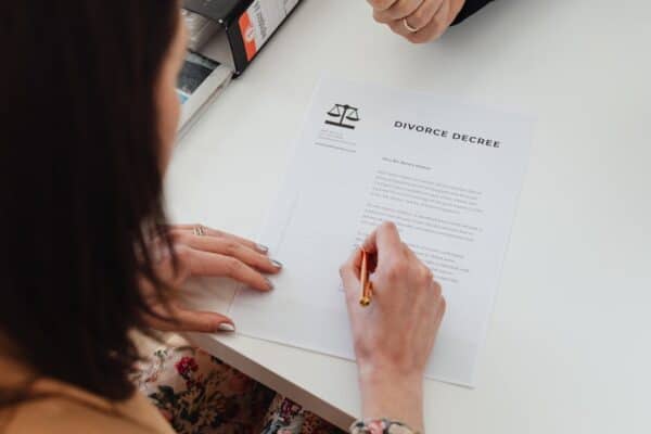 a-person-signing-a-divorce-decree-document-with-focus-on-hands-and-paper - Adam C. Gynac & Associates LLC Divorce Process in Will County Illinois What to Expect and How We Help Adam C Gynac Associates LLC Page 3