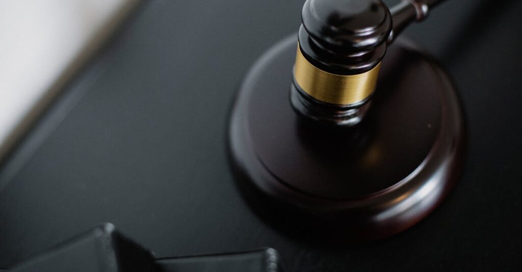 close-up-of-a-wooden-judge-s-gavel-on-a-black-desk-symbolizing-justice-and-law