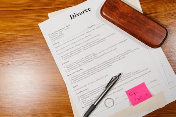 flat-lay-of-divorce-papers-with-a-pen-and-ring-on-a-wooden-table-for-legal-themes - Adam C. Gynac & Associates LLC How to File for Divorce in Will County Step by Step Guide Adam C Gynac Associates LLC